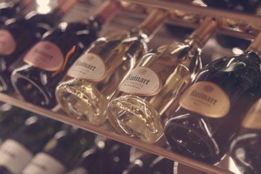 Paris, Fransa - Aralık 2019: Ruinart Blanc de Blancs Brut 'un restorandaki raflarda köpüren şampanya kadehleri. Şarap şişelerini kapatın..