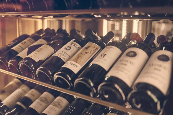 Moskova, Rusya - Aralık 2019: Restoranda büyük kırmızı şarapların sahnelenişi. Şarap şişelerini kapatın..