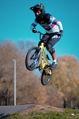 Moskova, Rusya - 19 Ekim 2019: Genç bir çocuk BMX motoruyla pompa pistinde zıplıyor. BMX yarışı. Pompa pistinde bisiklet sürüyor. Sürücü bisiklet sporunda iş başında. Bisikletli havalı bir sporcu. Pompalama bisikleti.
