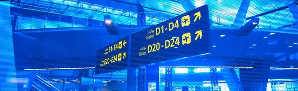 ゲート文字DとEを備えた空港での英語とアラビア語の黄色の照明記号出発便のための — ストック写真