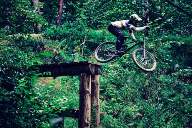 Rusya, Moskova - Sep 01, 2020: Ormanda MTB bisikletiyle atlayan genç çocuk. Profesyonel yokuş aşağı sürüş. Doğada bisiklete binen biri. Bisikletli havalı bir sporcu. MTB bisikleti.