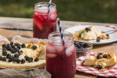 Cheesecake bir piknik masa üzerinde içkiyle meyve