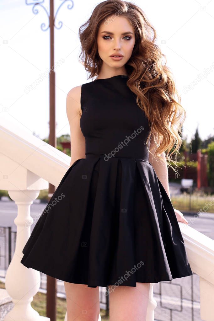 fashion outdoor photo of cute girl with freckles on face, with dark hair in elegant dress walking on the street in summer city