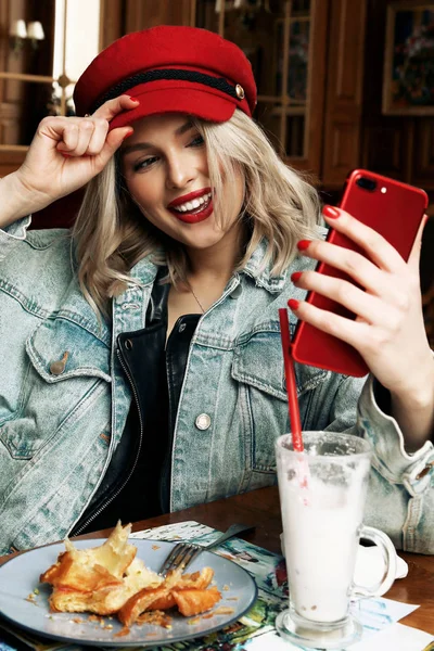 Hermosa mujer con cabello rubio en ropa casual y sombrero rojo si — Foto de Stock