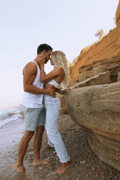 Lindo lindo casal vestindo jeans, posando na praia de verão — Fotografia de Stock