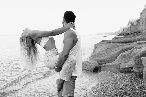 Hermosa pareja encantadora con pantalones vaqueros, posando en la playa de verano —  Fotos de Stock