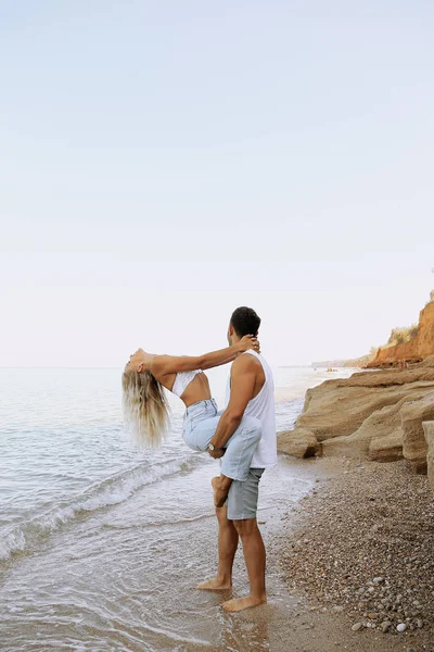 beautiful lovely couple wearing jeans,posing at summer beach