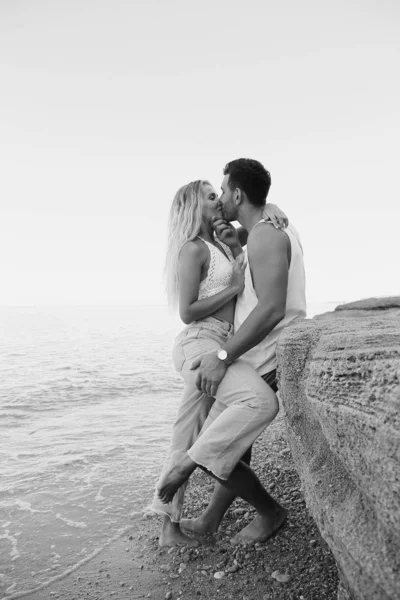 Hermosa pareja encantadora con pantalones vaqueros, posando en la playa de verano — Foto de Stock