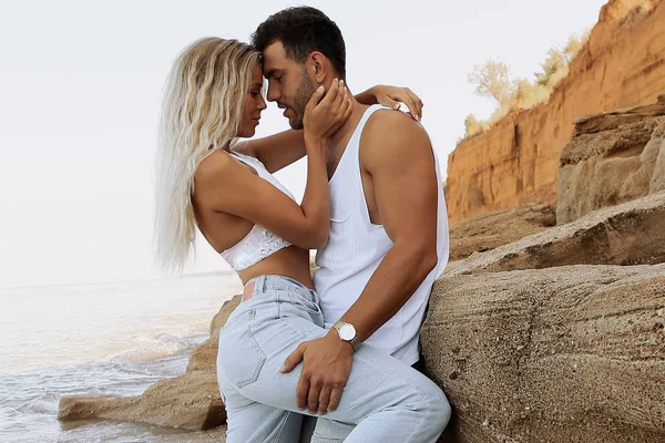 Lindo lindo casal vestindo jeans, posando na praia de verão — Fotografia de Stock