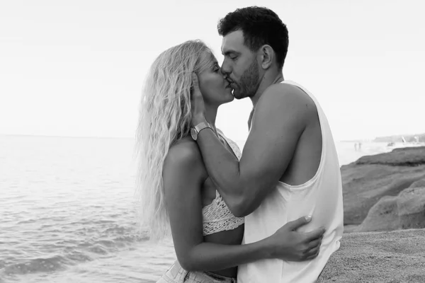 Hermosa pareja encantadora con pantalones vaqueros, posando en la playa de verano — Foto de Stock