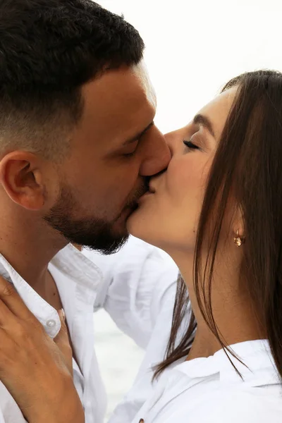 Hermosa pareja encantadora con pantalones vaqueros, posando en la playa de verano — Foto de Stock