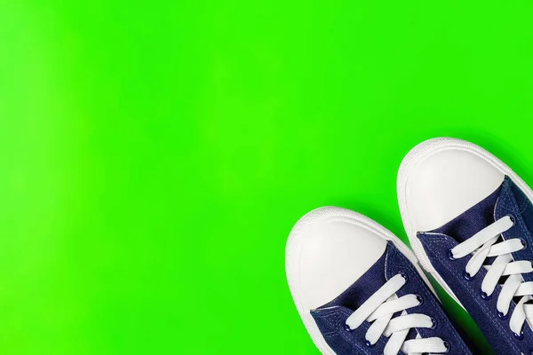 新的运动鞋在一个明亮的绿色背景 顶部视图 复制空间 — 图库照片