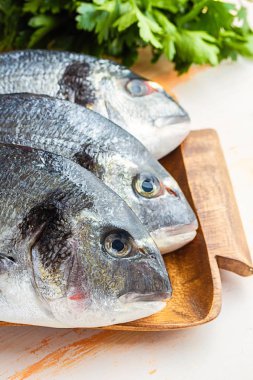 Üç ham dorado balık pişirmek hazır bir ahşap tepsi otlar ile yakın çekim