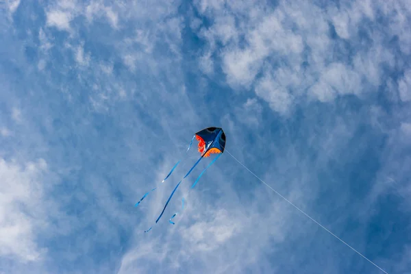 A kite soars in the bright blue cloudy sky. The concept of freedom, flight and joy. — Stock Photo, Image