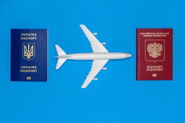 Ukrayna ve Rus pasaportu ve uçak modelleri mavi bir arka plan üzerinde. Ülkeler arasındaki hava trafiği yeniden başlamasını kavramı.
