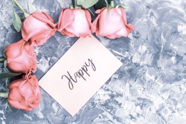 Romantik kavramı. Kırmızı gül ve mutlu bir gri üzerine yazı arka plan beton.