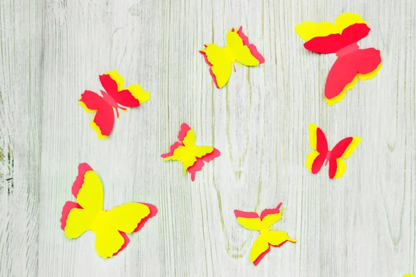 Farfalle di carta colorate su sfondo di legno. Attività di sviluppo dei bambini. Applicazione e origami. Posa piatta — Foto Stock