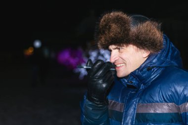 Ses asistanı. Günlük yaşamda modern teknoloji kullanımı. Mutlu genç adam onun smartphone içinde belgili tanımlık soğuk kışın bir ses verir.