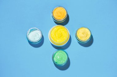 Parlak mavi bir arka plan üzerinde yüz kremi. Kozmetik kavramı