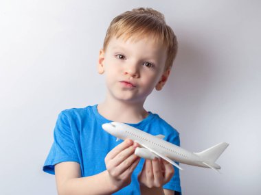 Altı yaşındaki bir çocuk bir yolcu uçağının oyuncak modeliyle oynuyor. Seyahat rüya konsepti