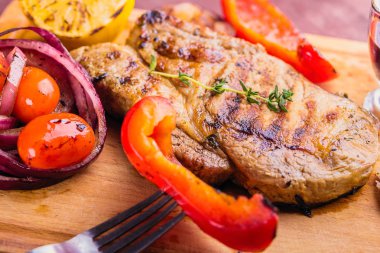 Sulu domuz biftek fışkın taze kekik, limon ve ızgara sebze yakın çekim ile