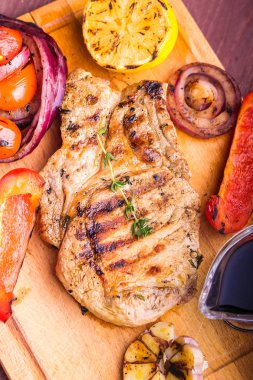 Taze kekik, limon ve ızgara sebze yakın çekim bir sprig ile sulu domuz biftek. Üstte görüntü