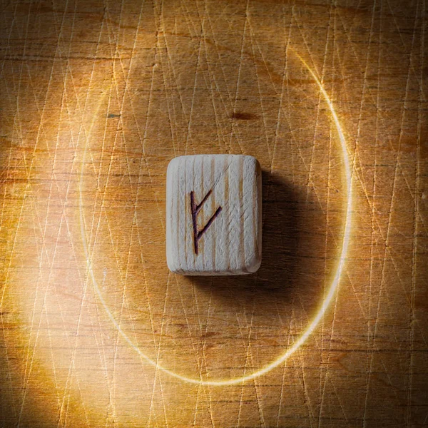 Fehu. Runes scandinaves en bois faites à la main sur un fond vintage en bois dans un cercle de lumière. Concept de la bonne aventure et prédiction de l'avenir — Photo