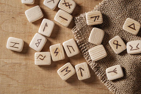 Handmade scandinavian wooden runes on a wooden vintage background. Concept of fortune telling and prediction of the future