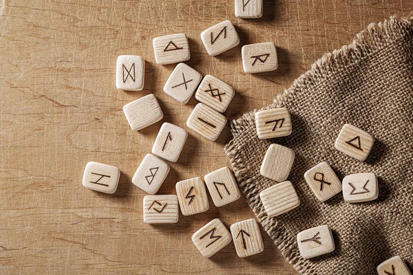 Handmade scandinavian wooden runes on a wooden vintage background. Concept of fortune telling and prediction of the future