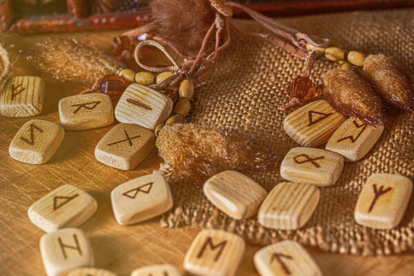 Деревянные руны ручной работы на деревянном винтажном фоне. Концепция гадания и предсказания будущего
