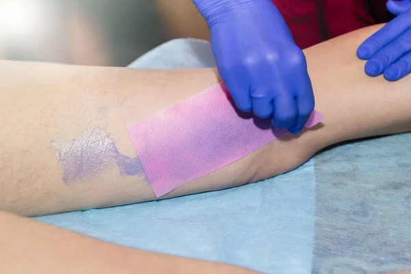 Schoonheidsspecialiste wassende been van vrouw met Wax Strip bij schoonheid kliniek — Stockfoto
