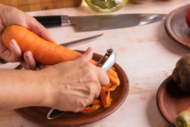 Cook bir soyucu yakın çekim ile havuç temizler. Organik pişirme konsepti