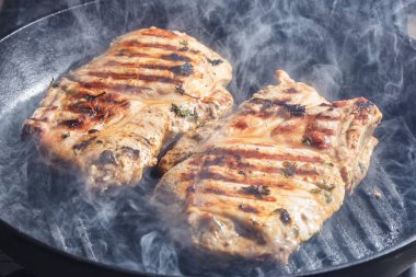 bir domuz biftek ızgara tava üzerinde duman ve Buhar yükselişi 