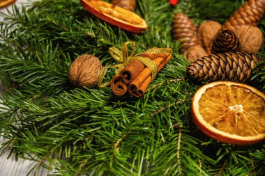 Yeni Yıl tatil süslemeleri. Fındık, tarçın ve kurutulmuş meyve suni kar ile toz ile köknar dalları El yapımı Noel çelenk
