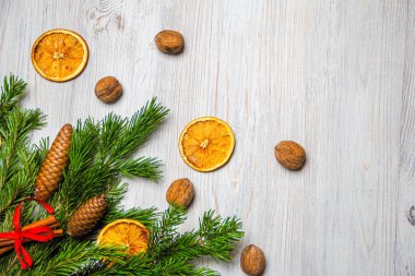 Noel ve Yeni Yıl kompozisyonu. Çam dalları, tarçın çubukları, portakal ve ceviz kurutulmuş dilimleri. Noel ve Yeni Yıl konsepti. Düz yatıyordu