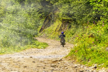 Ukrayna, Karpatlar. Toprak bir dağ yolunda bisiklet sürüyor.