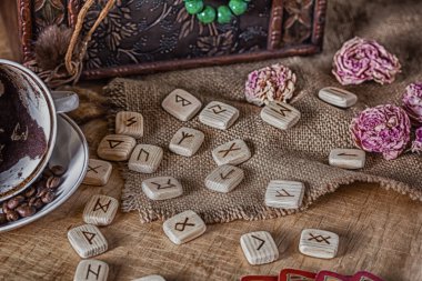 İzoterik kehanet ve tahmin kavramı. Tarot kartları, rünler, fincanda kahve telveleri, tespih, kurumuş bir çiçek eski bir göğsün arka planında..