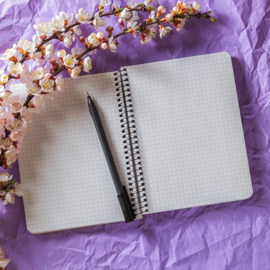 Boş defter, parlak arka planda çiçek açan kalem ve kiraz dalı aç. Mektup yazmak, yazışma kavramı.