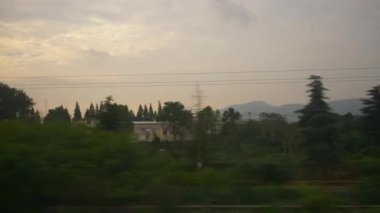 Günbatımı gökyüzü Wuhan Shenzhen tren yolu pencere kenarı pov panorama 4k porselen