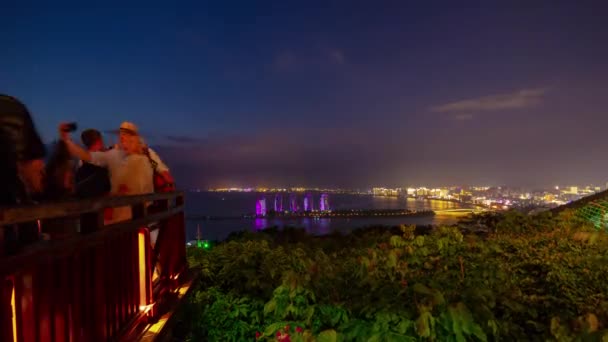 夜灯火通明的三亚公园拥挤的观景点著名的酒店全景4K 时间拉塞海南岛中国 — 图库视频影像