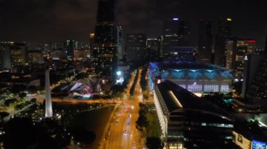 Singapur üzerinde Gece uçuş şehir trafiği havadan panorama 4k görüntüleri aydınlatılmış