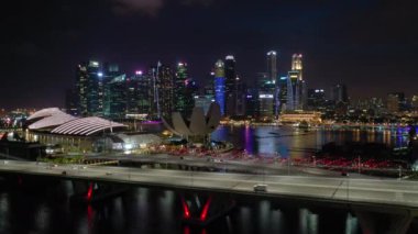 Singapur üzerinde Gece uçuş şehir trafiği havadan panorama 4k görüntüleri aydınlatılmış