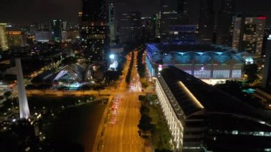 Singapur üzerinde Gece uçuş şehir trafiği havadan panorama 4k görüntüleri aydınlatılmış