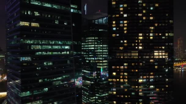 照らされたシンガポールの都市の空中パノラマ4K映像上の夜間飛行 — ストック動画