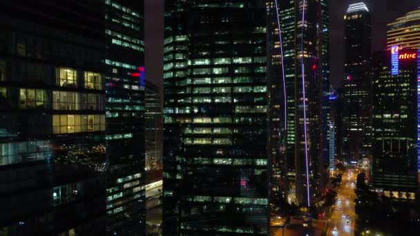 照らされたシンガポールの都市の空中パノラマ4K映像上の夜間飛行 — ストック動画