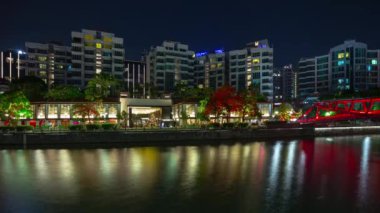 Singapur merkezindeki yaşam bloğunda gece aydınlatması, nehir kıyısındaki alışveriş hangarı, 4K, zaman atlaması.  