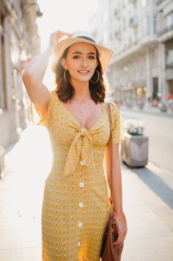 Sunset Bulvarında İspanya eski Avrupa sokakta şapkasını tutarak poz güzel genç esmer kadın