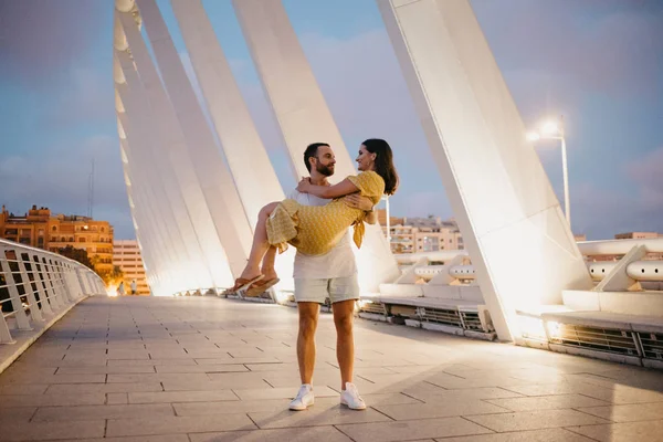 Sakallı şık adam güzel esmer kız gece İspanya köprüde onun kollarında tutar