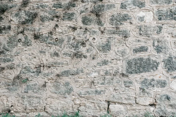 Siyah noktalar ile gri taş duvar. Farklı şekiller taşlarla