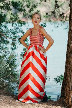 Dağ gölü poz kırmızı ve beyaz elbiseli şık bir sarışın Bayan. Sizi bekliyoruz. İspanya